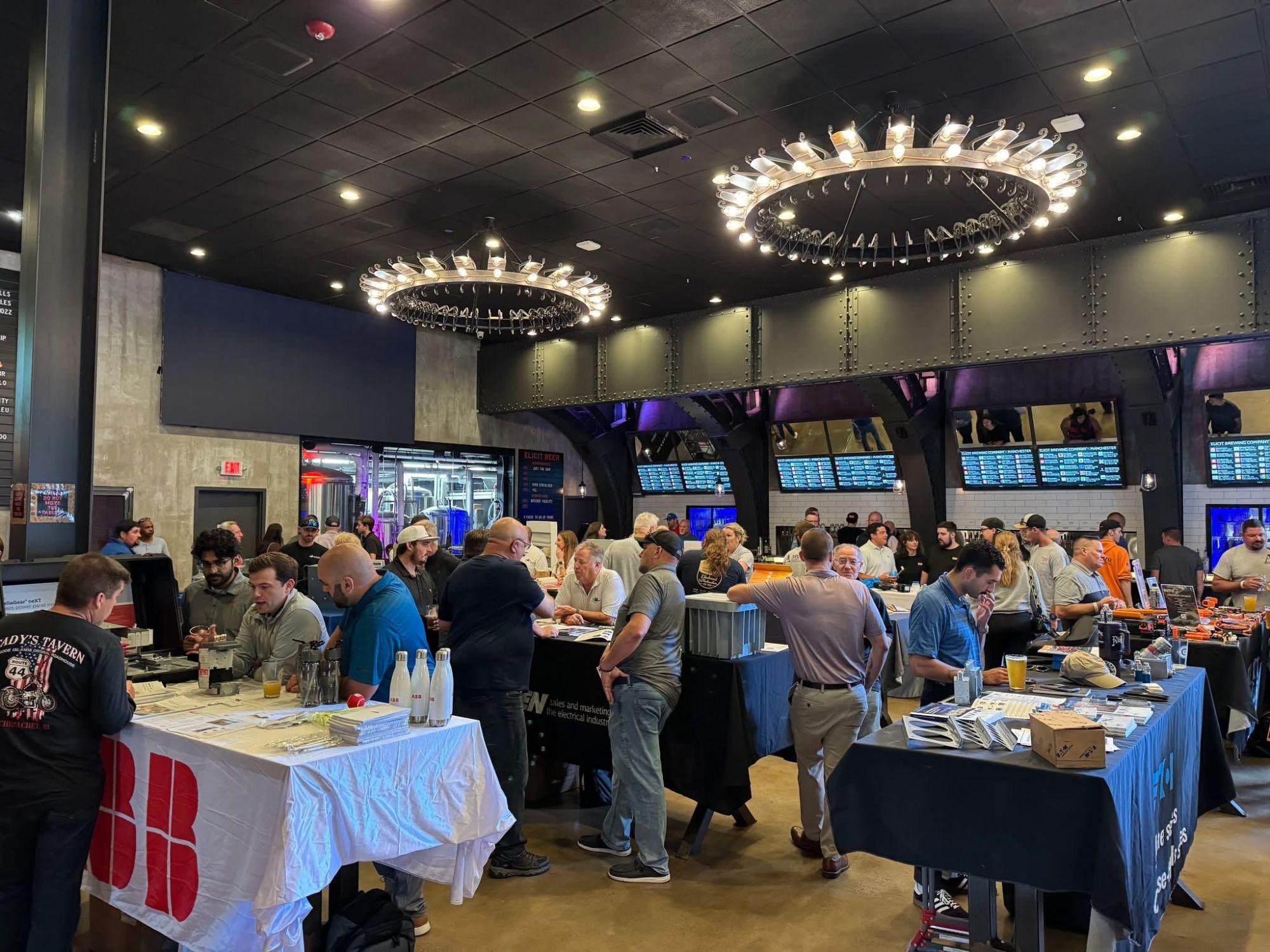 Guests gathered around vendor tables at an indoor event